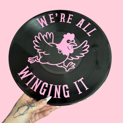 Black vinyl record with pink chicken illustration and text on a pink background
